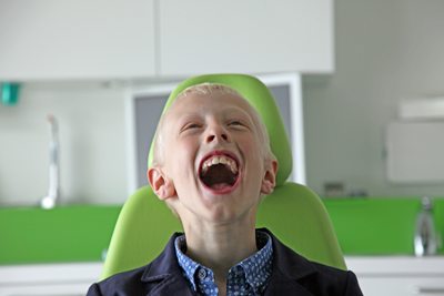 Een lachende jongen in de behandelstoel